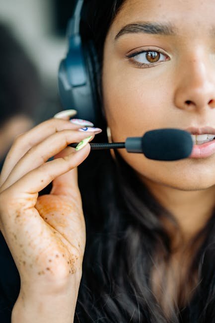 Close-up of a young woman working as a call center agent wearing a headset and microphone.